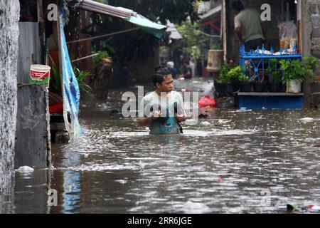 210218 -- JAKARTA, le 18 février 2021 -- un homme marche dans les eaux d'inondation après de fortes pluies à Jakarta, Indonésie, le 18 février 2021. Photo de /Xinhua INDONESIA-JAKARTA-FLOOD DedyxIstanto PUBLICATIONxNOTxINxCHN Banque D'Images