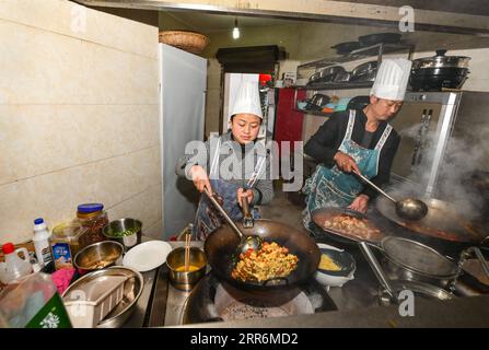 210222 -- QIANXI, le 22 février 2021 -- He LAN du groupe ethnique Miao et son mari Yang Changfu cuisinent pour les visiteurs lors de leur séjour à la ferme dans le village de Huawu, comté de Qianxi de la ville de Bijie, province du Guizhou au sud-ouest de la Chine, le 20 février 2021. Situé dans la région montagneuse profonde de Xinren Miao Township de Guizhou, Huawu Village est célèbre pour ses paysages étonnants. Ces dernières années, grâce aux efforts du gouvernement local, le village a développé la plantation, la culture et le tourisme tout en relocalisant les populations frappées par la pauvreté. De nos jours Huawu a pris un nouveau look dans la nouvelle année, avec diverses industries saluant boomin Banque D'Images