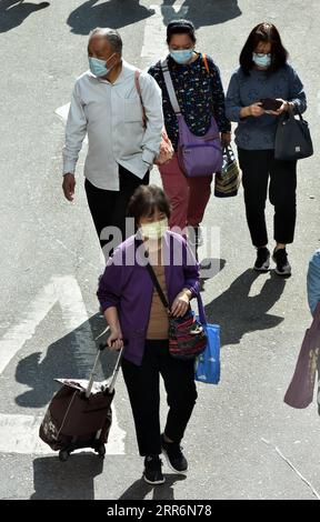 210223 -- HONG KONG, le 23 février 2021 -- des personnes portant des masques marchent dans la rue à Hong Kong, dans le sud de la Chine, le 23 février 2021. Le Centre de protection de la santé de Hong Kong CHP a signalé mardi 12 cas confirmés supplémentaires de COVID-19, portant son total à 10 896. CHINE-HONG KONG-COVID-19-CAS CN LOXPINGXFAI PUBLICATIONXNOTXINXCHN Banque D'Images