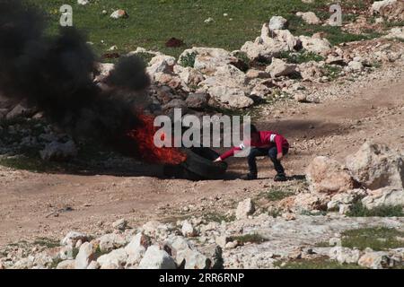 210226 -- NAPLOUSE, 26 février 2021 -- Un garçon palestinien brûle des pneus lors d'affrontements avec des soldats israéliens à la suite d'une manifestation contre l'expansion des colonies juives dans le village de Beit Dajan, en Cisjordanie, à l'est de Naplouse, le 26 février 2021. Photo de /Xinhua MIDEAST-NAPLOUSE-CLASHS NidalxEshtayeh PUBLICATIONxNOTxINxCHN Banque D'Images