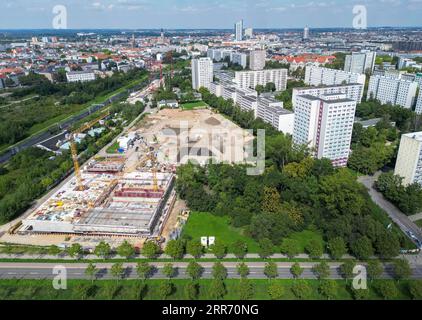 Leipzig, Allemagne. 23 août 2023. Les travaux de construction de l'école communautaire Campus Dösner Weg dans le sud de Leipzig progressent. Avec le plan de développement n° 397,1 'Stadtraum Bayerischer Bahnhof - Stadtquartier Lößniger Straße', un nouveau quartier sera créé sur les 36 hectares de friches. Un parc de huit hectares, environ 1 800 appartements, écoles, salles de sport, garderies, des magasins et environ 150 000 mètres carrés d'espace commercial sont prévus dans le quartier des deux côtés de la route du tunnel de la ville. (Photo aérienne avec drone) crédit : Jan Woitas/dpa/ZB/dpa/Alamy Live News Banque D'Images