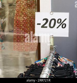 Avis de réduction de 20 % sur les vêtements dans un magasin de la vieille ville de Riva del Garda en Italie Banque D'Images