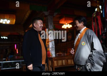 210312 -- YUSHU, le 12 mars 2021 -- Nyima L discute avec un homme de la mise en place d'un centre d'accueil touristique dans le canton de Lab du comté de Chindu, préfecture autonome tibétaine de Yushu, province du Qinghai au nord-ouest de la Chine, le 9 mars 2021. Nyima, 40 ans, est né dans une famille d'éleveurs dans le comté de Chindu de Yushu. Son père est bien connu localement comme artisan de l'architecture traditionnelle tibétaine. Influencé par son père, Nyima montre un grand intérêt pour l'architecture traditionnelle tibétaine depuis son enfance. En 2010, un violent tremblement de terre secoua Yushu et endommagea de nombreux bâtiments traditionnels tibétains Banque D'Images