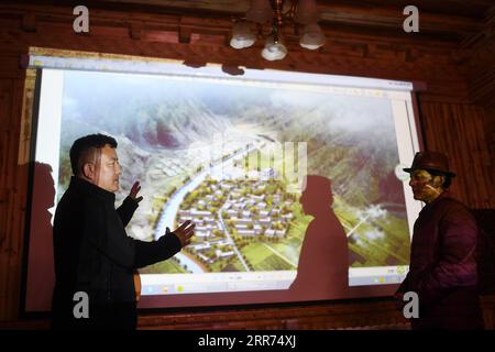 210312 -- YUSHU, 12 mars 2021 -- Nyima L discute du plan de réparation de villages tibétains traditionnels avec un héritier de la technique architecturale tibétaine dans la ville de Yushu, préfecture autonome tibétaine de Yushu, province du Qinghai, au nord-ouest de la Chine, 10 mars 2021. Nyima, 40 ans, est né dans une famille d'éleveurs dans le comté de Chindu de Yushu. Son père est bien connu localement comme artisan de l'architecture traditionnelle tibétaine. Influencé par son père, Nyima montre un grand intérêt pour l'architecture traditionnelle tibétaine depuis son enfance. En 2010, un violent tremblement de terre secoua Yushu et endommagea de nombreuses traditions Banque D'Images