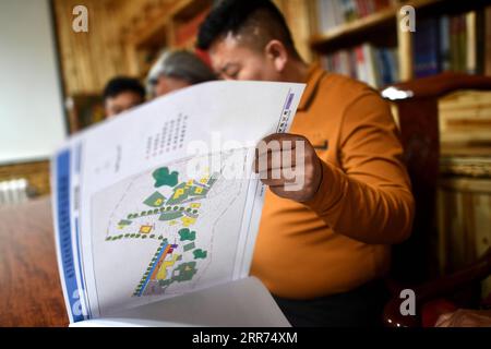 210312 -- YUSHU, 12 mars 2021 -- Nyima discute avec ses collègues d'une association de protection de l'architecture dans la préfecture autonome tibétaine de Yushu, province du Qinghai, au nord-ouest de la Chine, le 10 mars 2021. Nyima, 40 ans, est né dans une famille d'éleveurs dans le comté de Chindu de Yushu. Son père est bien connu localement comme artisan de l'architecture traditionnelle tibétaine. Influencé par son père, Nyima montre un grand intérêt pour l'architecture traditionnelle tibétaine depuis son enfance. En 2010, un violent tremblement de terre secoua Yushu et endommagea de nombreux bâtiments tibétains traditionnels, ce qui fit réaliser Nyima le U. Banque D'Images