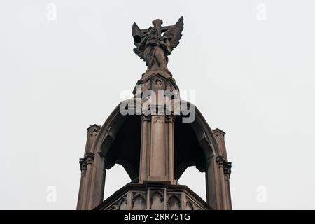 figure de statue d'ange religieux dans un temple dans un cimetière sur une journée nuageuse à l'extérieur Banque D'Images