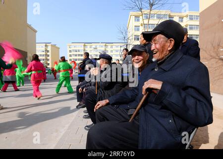 210316 -- TAIYUAN, le 16 mars 2021 -- Liu Qingji R aime danser le yangge dans un complexe résidentiel pour villageois réinstallés dans la ville de Yukou, dans le comté de Fangshan, province du Shanxi, dans le nord de la Chine, le 9 mars 2021. Shijiamao est un petit village situé dans des zones montagneuses accidentées avec peu de précipitations. Comme d’autres villageois ici, Liu Qingji, un agriculteur de 85 ans, pratiquait l’agriculture à la merci des éléments. Ayant habité de nombreuses années dans un sombre yaodong , une maison construite dans la terre durcie commune à travers le plateau de Loess dans le nord de la Chine, Liu espérait améliorer les conditions de vie et avoir accès au fre Banque D'Images