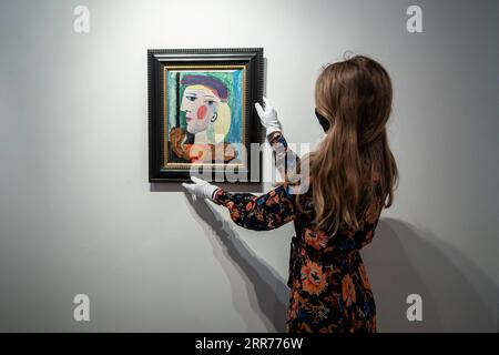 210316 -- PARIS, le 16 mars 2021 -- un membre du personnel présente Femme au Beret mauve à la maison de vente aux enchères Bonhams à Paris, France, le 16 mars 2021. Selon la maison de vente aux enchères Bonhams, Femme au Beret mauve, peinte par l’artiste espagnol Pablo Picasso en mars 1937, devrait être vendue aux enchères à New York en mai 2021. Photo par /Xinhua FRANCE-PARIS-FEMME au BERET MAUVE-AurelienxMorisard PUBLICATIONxNOTxINxCHN Banque D'Images