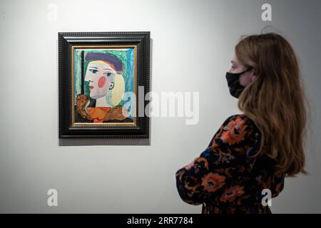 210316 -- PARIS, le 16 mars 2021 -- un membre du personnel voit Femme au Beret mauve à la maison de vente aux enchères Bonhams à Paris, France, le 16 mars 2021. Selon la maison de vente aux enchères Bonhams, Femme au Beret mauve, peinte par l’artiste espagnol Pablo Picasso en mars 1937, devrait être vendue aux enchères à New York en mai 2021. Photo par /Xinhua FRANCE-PARIS-FEMME au BERET MAUVE-AurelienxMorisard PUBLICATIONxNOTxINxCHN Banque D'Images