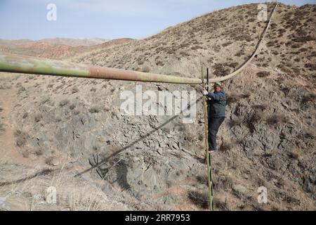 210321 -- SUNAN, le 21 mars 2021 -- Gu Zhengli inspecte un pipeline dans le canton de Dahe, comté autonome de Yugu de Sunan, province du Gansu, au nord-ouest de la Chine, le 20 mars 2021. Gu Zhengli, 59 ans, travaille sur la ligne de front du projet de conservation de l’eau de Tanggaer dans le canton de Dahe depuis 42 ans, protégeant la sécurité de l’eau potable pour la population locale et le bétail. Comme les précipitations annuelles dans la ville ne sont que de 150 à 300 millimètres, le projet de conservation de l'eau de Tanggaer est littéralement la bouée de sauvetage pour les éleveurs locaux. Chaque matin, Gu se lève tôt et fait fonctionner une pompe pour déplacer l'eau de la stati de pompage Banque D'Images