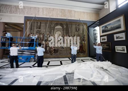 210322 -- ATHÈNES, le 22 mars 2021 -- des travailleurs accrochent une tapisserie représentant l'école d'Athènes à l'intérieur du Parlement grec à Athènes, en Grèce, le 22 mars 2021. Une rare tapisserie du 18e siècle représentant l'artiste italien de la Renaissance Raphaël, chef-d'œuvre de l'école d'Athènes, a été exposée au Parlement grec lundi. L'œuvre, reproduction de la fresque de Raphaël à l'intérieur du Musée du Vatican, a été prêtée à la Grèce à l'occasion du 200e anniversaire du début de la guerre d'indépendance grecque, qui sera célébré ce jeudi. /Document via Xinhua GRÈCE-ATHÈNES-FRANCE-TAPISSERIE-PRÊTÉE G Banque D'Images