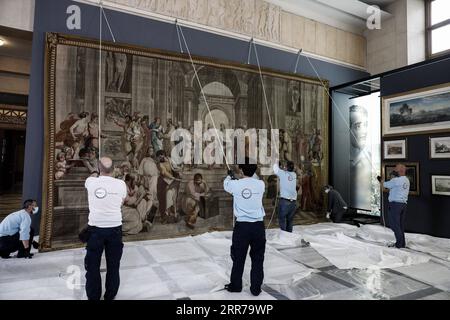 210322 -- ATHÈNES, le 22 mars 2021 -- des travailleurs accrochent une tapisserie représentant l'école d'Athènes à l'intérieur du Parlement grec à Athènes, en Grèce, le 22 mars 2021. Une rare tapisserie du 18e siècle représentant l'artiste italien de la Renaissance Raphaël, chef-d'œuvre de l'école d'Athènes, a été exposée au Parlement grec lundi. L'œuvre, reproduction de la fresque de Raphaël à l'intérieur du Musée du Vatican, a été prêtée à la Grèce à l'occasion du 200e anniversaire du début de la guerre d'indépendance grecque, qui sera célébré ce jeudi. /Document via Xinhua GRÈCE-ATHÈNES-FRANCE-TAPISSERIE-PRÊTÉE G Banque D'Images