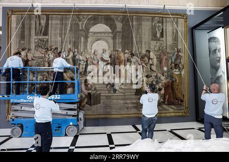 210322 -- ATHÈNES, le 22 mars 2021 -- des travailleurs accrochent une tapisserie représentant l'école d'Athènes à l'intérieur du Parlement grec à Athènes, en Grèce, le 22 mars 2021. Une rare tapisserie du 18e siècle représentant l'artiste italien de la Renaissance Raphaël, chef-d'œuvre de l'école d'Athènes, a été exposée au Parlement grec lundi. L'œuvre, reproduction de la fresque de Raphaël à l'intérieur du Musée du Vatican, a été prêtée à la Grèce à l'occasion du 200e anniversaire du début de la guerre d'indépendance grecque, qui sera célébré ce jeudi. /Document via Xinhua GRÈCE-ATHÈNES-FRANCE-TAPISSERIE-PRÊTÉE G Banque D'Images