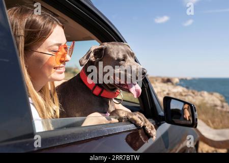 Vue latérale jeune femme chien aller voyage Banque D'Images