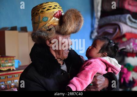 210325 -- LHASSA, le 25 mars 2021 -- Basang tient son arrière-petite-fille de 9 mois chez lui dans le village de Taye de Xigaze, dans la région autonome du Tibet du sud-ouest de la Chine, le 21 mars 2021. Basang, né en 1934, est un villageois du village de Taye à Xigaze, dans la région autonome du Tibet en Chine. Dans le passé, la famille de Basang devait payer divers impôts aux propriétaires de serfs, ce qui faisait que la famille menait une vie misérable. Le nombre d’impôts que nous avons payés était encore plus que des ondulations dans l’eau et des étoiles dans le ciel, a rappelé Basang. Une nouvelle vie a commencé à embrasser la famille de Basang en 1959, après une réforme démocratique liberat Banque D'Images