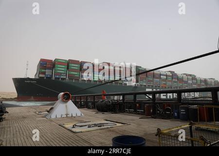 210325 -- LE CAIRE, le 25 mars 2021 -- Un navire de sauvetage travaille sur le site d'un porte-conteneurs piégé sur le canal de Suez en Égypte le 25 mars 2021. La navigation dans le canal de Suez a été suspendue temporairement jusqu’à ce que les travaux de re-flottation sur un navire échoué sur une nouvelle route soient terminés, a déclaré jeudi Osama Rabie, président de la SCA. Le porte-conteneurs de 224 000 tonnes jamais donné, un navire porte-conteneurs battant pavillon panaméen, a été cloué au sol mardi dans le nouveau passage après avoir perdu la capacité de se diriger au milieu de vents violents et d'une tempête de poussière, a déclaré la SCA dans un communiqué mercredi. /Document via Xinhua EGYPT-SUEZ CANAL-CONTENEUR DE FRET Banque D'Images