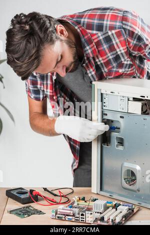 Jeune technicien masculin examinant l'atelier informatique Banque D'Images