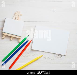 Blanc mini chevalet papier blanc couleurs stylo feutre fond de texture en bois Banque D'Images