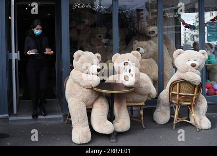 210326 -- PARIS, le 26 mars 2021 -- le propriétaire du café bouquet Wagram, qui offre des services à emporter, sert du café aux ours en peluche géants à Paris, France, le 26 mars 2021. Le ministre français de la Santé Olivier Veran a annoncé jeudi des mesures de freinage renforcées dans trois autres régions à haut risque COVID-19 - Rhône, Aube et Nièvre - dans le but de contenir une troisième vague de la pandémie. FRANCE-PARIS-OURS EN PELUCHE GÉANTS GaoxJing PUBLICATIONxNOTxINxCHN Banque D'Images