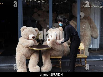 210326 -- PARIS, le 26 mars 2021 -- le propriétaire du café bouquet Wagram, qui offre des services à emporter, transporte un ours en peluche géant à Paris, France, le 26 mars 2021. Le ministre français de la Santé Olivier Veran a annoncé jeudi des mesures de freinage renforcées dans trois autres régions à haut risque COVID-19 - Rhône, Aube et Nièvre - dans le but de contenir une troisième vague de la pandémie. FRANCE-PARIS-OURS EN PELUCHE GÉANTS GaoxJing PUBLICATIONxNOTxINxCHN Banque D'Images