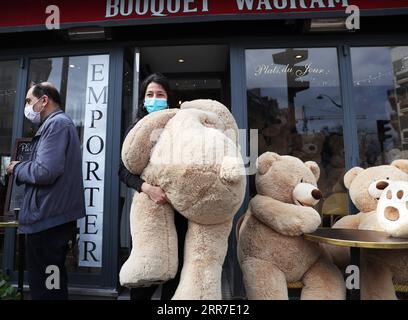 210326 -- PARIS, le 26 mars 2021 -- le propriétaire du café bouquet Wagram, qui offre des services à emporter, transporte un ours en peluche géant à Paris, France, le 26 mars 2021. Le ministre français de la Santé Olivier Veran a annoncé jeudi des mesures de freinage renforcées dans trois autres régions à haut risque COVID-19 - Rhône, Aube et Nièvre - dans le but de contenir une troisième vague de la pandémie. FRANCE-PARIS-OURS EN PELUCHE GÉANTS GaoxJing PUBLICATIONxNOTxINxCHN Banque D'Images