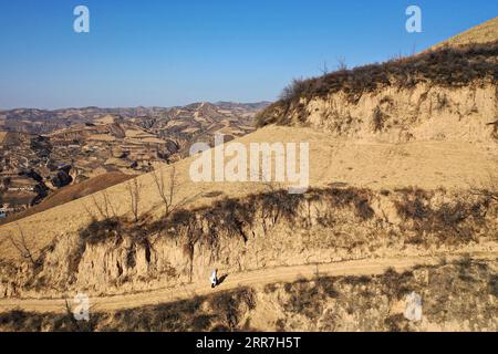 210329 -- TAIYUAN, le 29 mars 2021 -- une photo aérienne prise le 23 mars 2021 montre Zhang Shangbao marchant le long d'un chemin pour des visites à domicile dans le village de Tietou, dans le comté de Shilou, dans la province du Shanxi du nord de la Chine. Zhang, 61 ans, qui n’a qu’une seule main, marche à travers les montagnes jour après jour depuis 1976, protégeant la santé des habitants. Il y a plus de 600 villageois vivant dans 5 hameaux du village de Tietou niché dans les montagnes de Lyuliang. Dans le passé, il était difficile d'accéder aux soins de santé, ce qui avait tourmenté les masses ici depuis longtemps. En 1976, Zhang Shangbao a obtenu son diplôme de santé Banque D'Images