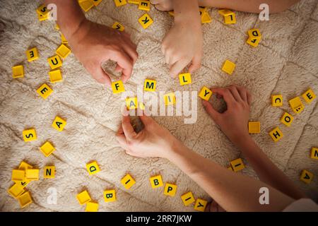 Mains jouant scrabble jeu tapis à la maison Banque D'Images