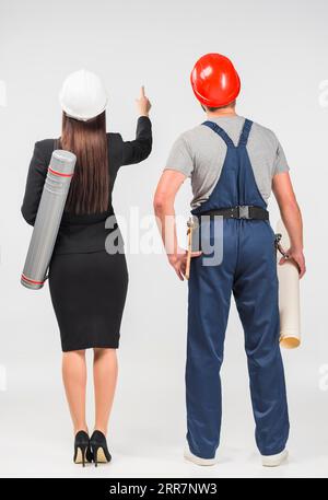 Femme ingénieur debout avec le constructeur pointant vers le haut Banque D'Images