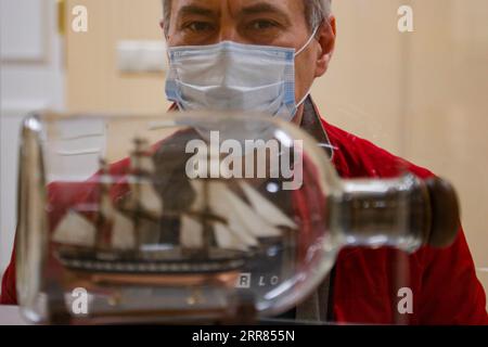 210418 -- MOSCOU, le 18 avril 2021 -- Un visiteur regarde une maquette de navire pendant le Championnat de Russie et la Moscow Open Cup en modélisation de navire à Moscou, Russie, le 18 avril 2021. Plus de 160 modèles de navires et de navires, des plus petits de 10-15 centimètres de long aux grands modèles de plus de 1,5 mètres de long, ont été présentés lors de la compétition. Photo de /Xinhua RUSSIE-MOSCOU-CHAMPIONNAT DE MODÈLE DE NAVIRE AlexanderxZemlianichenkoxJr PUBLICATIONxNOTxINxCHN Banque D'Images