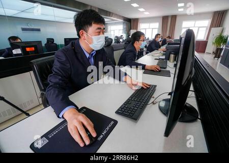 210421 -- URUMQI, 21 avril 2021 -- Niu Ruiqing 1st L vérifie le fonctionnement de l'équipement via un écran d'ordinateur à la division de maintenance des voies et des machines à Urumqi, dans la région autonome ouygur du Xinjiang, au nord-ouest de la Chine, le 3 mars 2021. Un relais de carrière de trois générations sur 70 ans au sein de la même famille a été témoin du développement étonnant du transport ferroviaire dans la région autonome ouïgoure du Xinjiang du nord-ouest de la Chine. Le Xinjiang a toujours été bien connu pour son environnement géologique et climatique rigoureux allant de vastes déserts, montagnes enneigées, vents dévastateurs, marais salés, tout cela Banque D'Images