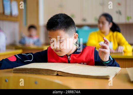 210422 -- CHONGQING, le 22 avril 2021 -- un élève malvoyant écoute un livre pendant un cours d'écoute au Centre d'éducation spéciale de Chongqing, dans la municipalité de Chongqing, dans le sud-ouest de la Chine, le 22 avril 2021. En prévision de la Journée mondiale du livre qui tombe le 23 avril, le Centre d'éducation spéciale de Chongqing a lancé une série d'activités telles que l'ouverture de cours de livres audio, l'organisation de coins de lecture et l'offre de plus de livres en braille pour les enfants malvoyants. CHINE-CHONGQING-JOURNÉE MONDIALE DU LIVRE-ÉDUCATION SPÉCIALE CN LIUXCHAN PUBLICATIONXNOTXINXCHN Banque D'Images