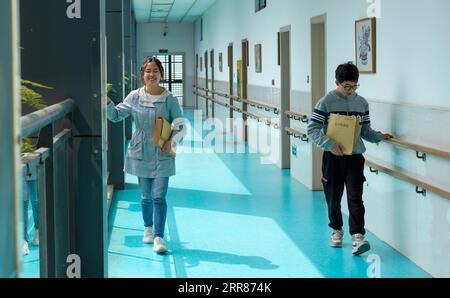 210422 -- CHONGQING, le 22 avril 2021 -- deux étudiants qui ont emprunté des livres à la bibliothèque de l'école retournent à la salle de classe du Centre d'éducation spéciale de Chongqing, dans la municipalité de Chongqing, dans le sud-ouest de la Chine, le 22 avril 2021. En prévision de la Journée mondiale du livre qui tombe le 23 avril, le Centre d'éducation spéciale de Chongqing a lancé une série d'activités telles que l'ouverture de cours de livres audio, l'organisation de coins de lecture et l'offre de plus de livres en braille pour les enfants malvoyants. CHINE-CHONGQING-JOURNÉE MONDIALE DU LIVRE-ÉDUCATION SPÉCIALE CN LIUXCHAN PUBLICATIONXNOTXINXCHN Banque D'Images