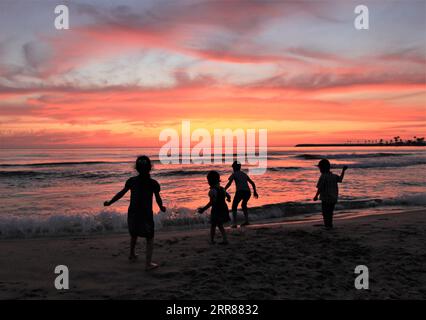 210423 -- BEYROUTH, le 23 avril 2021 -- des enfants sont silhouettés au coucher du soleil au bord de la mer à Beyrouth, au Liban, le 23 avril 2021. LIBAN-BEYROUTH-BORD DE MER-COUCHER DE SOLEIL LiuxZongya PUBLICATIONxNOTxINxCHN Banque D'Images