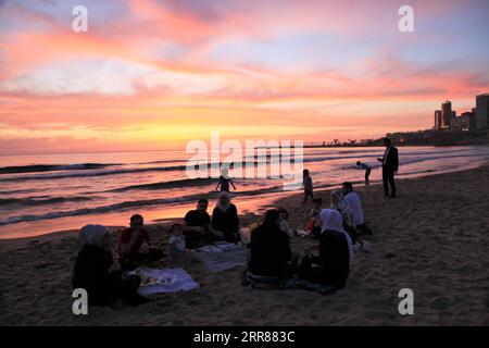 210423 -- BEYROUTH, le 23 avril 2021 -- les gens apprécient l'iftar sur la plage au coucher du soleil à Beyrouth, Liban, le 23 avril 2021. LIBAN-BEYROUTH-BORD DE MER-COUCHER DE SOLEIL LiuxZongya PUBLICATIONxNOTxINxCHN Banque D'Images