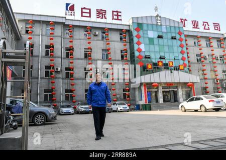 210424 -- TAIYUAN, le 24 avril 2021 -- Zhang Hai marche près de l'immeuble de bureaux de la mine Baijiazhuang du groupe de charbon à coke de Shanxi dans la province du Shanxi du nord de la Chine, le 11 mars 2021. Zhang Lianggui, son fils Zhang Hai et son petit-fils Zhang Shiqi avaient tous travaillé comme mineurs de charbon. L histoire acharnée de cette famille de mineurs de charbon sur trois générations illustre l essor de l industrie minière chinoise, de l homme à la technologie. Âgé de près de 90 ans, Zhang Lianggui est un mineur de charbon à la retraite. Recruté en 1954, il se souvient des conditions de travail difficiles des mineurs de charbon à l’époque, dont beaucoup Banque D'Images