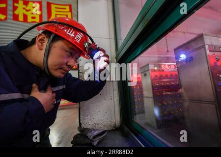 210424 -- TAIYUAN, le 24 avril 2021 -- Zhang Shiqi se prépare à entrer dans un tunnel minier à la mine du erping du Groupe de charbon à coke de Shanxi dans la province du Shanxi du nord de la Chine, le 18 mars 2021. Zhang Lianggui, son fils Zhang Hai et son petit-fils Zhang Shiqi avaient tous travaillé comme mineurs de charbon. L histoire acharnée de cette famille de mineurs de charbon sur trois générations illustre l essor de l industrie minière chinoise, de l homme à la technologie. Âgé de près de 90 ans, Zhang Lianggui est un mineur de charbon à la retraite. Recruté en 1954, il se souvient des conditions de travail difficiles des mineurs de charbon à l’époque, dont beaucoup Banque D'Images