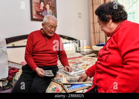 210424 -- TAIYUAN, 24 avril 2021 -- Zhang Lianggui regarde de vieilles photos avec sa femme Li Qiaoxian chez eux dans la province du Shanxi, dans le nord de la Chine, le 10 mars 2021. Zhang Lianggui, son fils Zhang Hai et son petit-fils Zhang Shiqi avaient tous travaillé comme mineurs de charbon. L histoire acharnée de cette famille de mineurs de charbon sur trois générations illustre l essor de l industrie minière chinoise, de l homme à la technologie. Âgé de près de 90 ans, Zhang Lianggui est un mineur de charbon à la retraite. Recruté en 1954, il se souvient des conditions de travail difficiles des mineurs de charbon à l’époque, dont beaucoup ont dû se pencher Banque D'Images