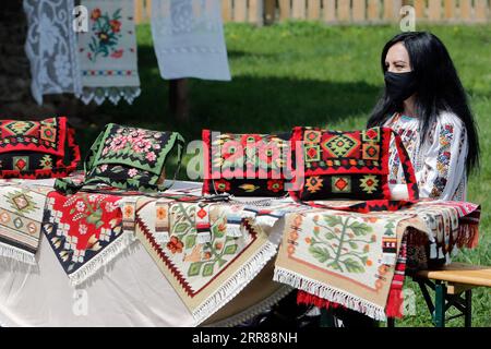 210425 -- BUCAREST, le 25 avril 2021 -- un artisan attend des clients lors d'une foire artisanale traditionnelle de printemps organisée au Musée du Village de Roumanie à Bucarest, Roumanie, le 24 avril 2021. Des artisans de tout le pays sont arrivés au Musée du Village pour prouver leurs talents d’artisanat et vendre leurs produits. Photo par /Xinhua ROUMANIE-BUCAREST-ARTISANAT-FOIRE ARTISANALE CristianxCristel PUBLICATIONxNOTxINxCHN Banque D'Images