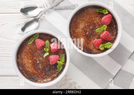 Crème brulée au chocolat des fêtes avec baies sur le dessus gros plan dans un ramequin sur la table. Vue de dessus horizontale Banque D'Images