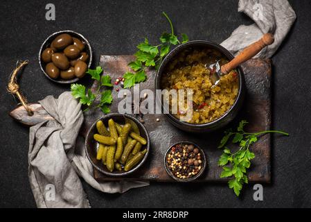 Salade d'hiver rafraîchissante de concombres marinés et d'olives, sur un fond en bois sombre Banque D'Images