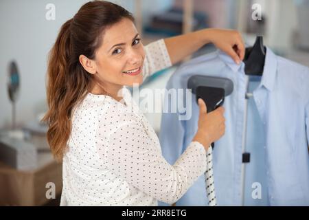 femme fumant chemise chez les nettoyeurs à sec Banque D'Images