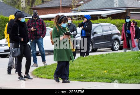 210505 -- TORONTO, le 5 mai 2021 -- des personnes portant un masque facial font la queue pour entrer dans une clinique de vaccination contre la COVID-19 à Toronto, Ontario, Canada, le 5 mai 2021. L Ontario, la province la plus peuplée du Canada, a signalé 2 941 nouveaux cas de COVID-19 mercredi matin, ce qui porte le total cumulatif du pays à 1 252 891 cas, selon CTV. Photo de /Xinhua CANADA-ONTARIO-COVID-19-CAS ZouxZheng PUBLICATIONxNOTxINxCHN Banque D'Images