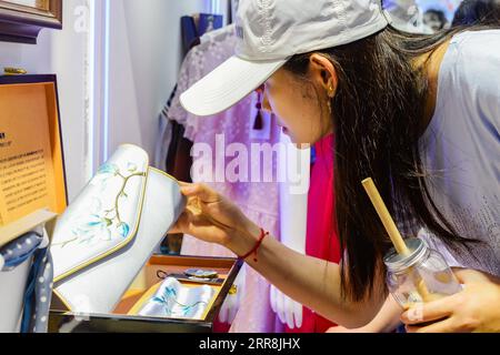 210510 -- HAIKOU, le 10 mai 2021 -- Un visiteur voit un porte-monnaie brodé exposé lors de la première exposition internationale des produits de consommation en Chine à Haikou, capitale de la province de Hainan du sud de la Chine, le 10 mai 2021. Les expositions nationales avec des caractéristiques chinoises sont tout à fait un spectacle à l'Expo, non seulement répondant aux besoins des consommateurs, mais reflétant également le charme unique de la culture chinoise. CHINA-HAINAN-HAIKOU-INT L PRODUITS DE CONSOMMATION EXPO-CHINESE STYLE CN ZHOUXJIAYI PUBLICATIONXNOTXINXCHN Banque D'Images