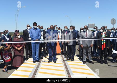 210511 -- GABORONE, le 11 mai 2021 -- le président botswanais Mokgweetsi Masisi coupe le ruban pour marquer l'ouverture officielle du pont de Kazungula reliant le Botswana et la Zambie le 10 mai 2021. Lundi, le Botswana et la Zambie ont ouvert conjointement le pont de Kazungula, qui est composé d'une route et d'une voie ferrée sur le fleuve Zambèze qui relie les deux pays, ainsi que d'un poste frontière à guichet unique. Photo de /Xinhua BOTSWANA-ZAMBIE-BRIDGE TshekisoxTebalo PUBLICATIONxNOTxINxCHN Banque D'Images