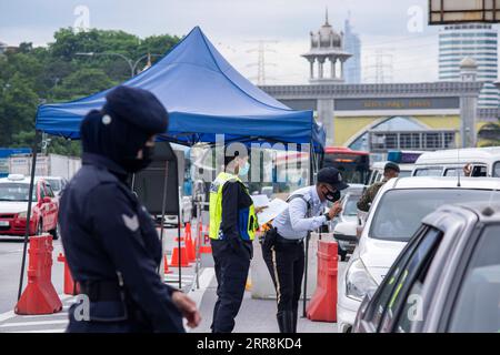 210511 -- KUALA LUMPUR, le 11 mai 2021 -- la police vérifie les véhicules qui passent dans le cadre de l'ordonnance de contrôle des mouvements visant à freiner la pandémie de COVID-19 sur une grande voie reliant Selangor et Kuala Lumpur, à Petaling Jaya, Malaisie, le 11 mai 2021. La Malaisie a enregistré 3 973 nouveaux cas de COVID-19, portant le total à 448 457, a déclaré mardi le ministère de la Santé. Photo de /Xinhua MALAISIE-COVID-19-CAS ChongxVoonxChung PUBLICATIONxNOTxINxCHN Banque D'Images