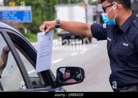 210511 -- KUALA LUMPUR, le 11 mai 2021 -- Un policier vérifie les véhicules qui passent dans le cadre de l'ordonnance de contrôle des mouvements visant à freiner la pandémie de COVID-19 sur une route reliant Selangor et Kuala Lumpur, à Petaling Jaya, Malaisie, le 11 mai 2021. La Malaisie a enregistré 3 973 nouveaux cas de COVID-19, portant le total à 448 457, a déclaré mardi le ministère de la Santé. Photo de /Xinhua MALAISIE-COVID-19-CAS ChongxVoonxChung PUBLICATIONxNOTxINxCHN Banque D'Images