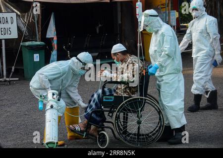210513 -- SURABAYA, le 13 mai 2021 -- des agents de santé viennent en aide à un patient atteint du COVID-19 dans un hôpital temporaire de Surabaya, Java oriental, Indonésie, le 13 mai 2021. Le nombre de cas de COVID-19 en Indonésie a augmenté de 3 448 en un jour pour atteindre 1 731 652, le nombre de décès s’élevant de 99 à 47.716, a déclaré jeudi le ministère de la Santé. Photo de /Xinhua INDONESIA-SURABAYA-COVID-19-CAS AdityaxHendra PUBLICATIONxNOTxINxCHN Banque D'Images