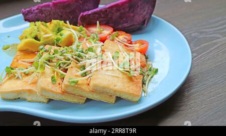 Assiette de tofu grillé et salade Daikon Microgreens fraîche avec patates douces violettes cuites à la vapeur Banque D'Images