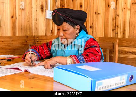 210518 -- NANNING, le 18 mai 2021 -- Pan Jiping remplit les dossiers médicaux du village de Xiaozhai, dans le canton de Longji, comté de Longsheng, région autonome de Guangxi Zhuang, dans le sud de la Chine, le 18 mai 2021. À Xiaozhai, un village au pied de la montagne Fupingbao à plus de 1 900 mètres d'altitude, Pan Jiping est médecin de campagne ici depuis plus de 30 ans. PAN, 57 ans, est l'un des Hongyao, une branche du groupe ethnique Yao. En 1988, Pan est allé à l'école de santé du comté pour étudier la médecine afin de résoudre les difficultés des villageois à voir un médecin. En 1990, après avoir terminé ses études, Pan revient Banque D'Images