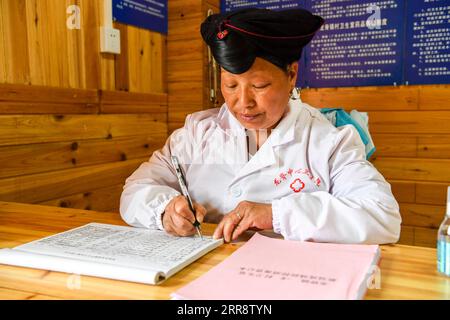 210518 -- NANNING, le 18 mai 2021 -- Pan Jiping remplit un journal de travail au village de Xiaozhai, dans le canton de Longji, comté de Longsheng, région autonome de Guangxi Zhuang, dans le sud de la Chine, le 18 mai 2021. À Xiaozhai, un village au pied de la montagne Fupingbao à plus de 1 900 mètres d'altitude, Pan Jiping est médecin de campagne ici depuis plus de 30 ans. PAN, 57 ans, est l'un des Hongyao, une branche du groupe ethnique Yao. En 1988, Pan est allé à l'école de santé du comté pour étudier la médecine afin de résoudre les difficultés des villageois à voir un médecin. En 1990, après avoir terminé ses études, Pan return Banque D'Images